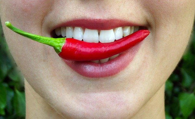 Csípős chilibe harap és mosolyog