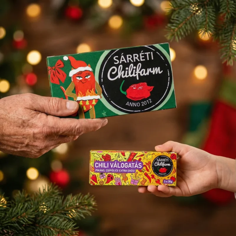 Két dobozos chili válogatás kézben tartva karácsonyi hangulatban